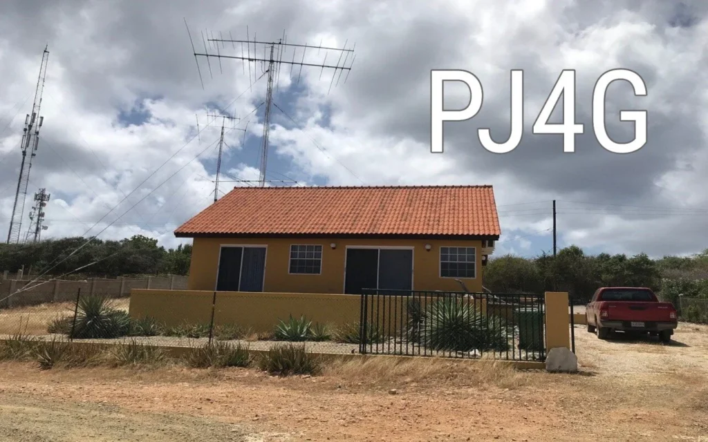 Estação de rádio PJ4G em Bonaire com antenas e casa amarela