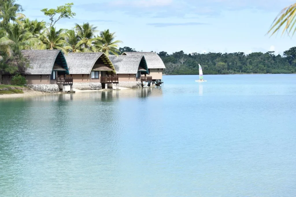 Bungalows à beira da água em Vanuatu, cercados por palmeiras e mar calmo