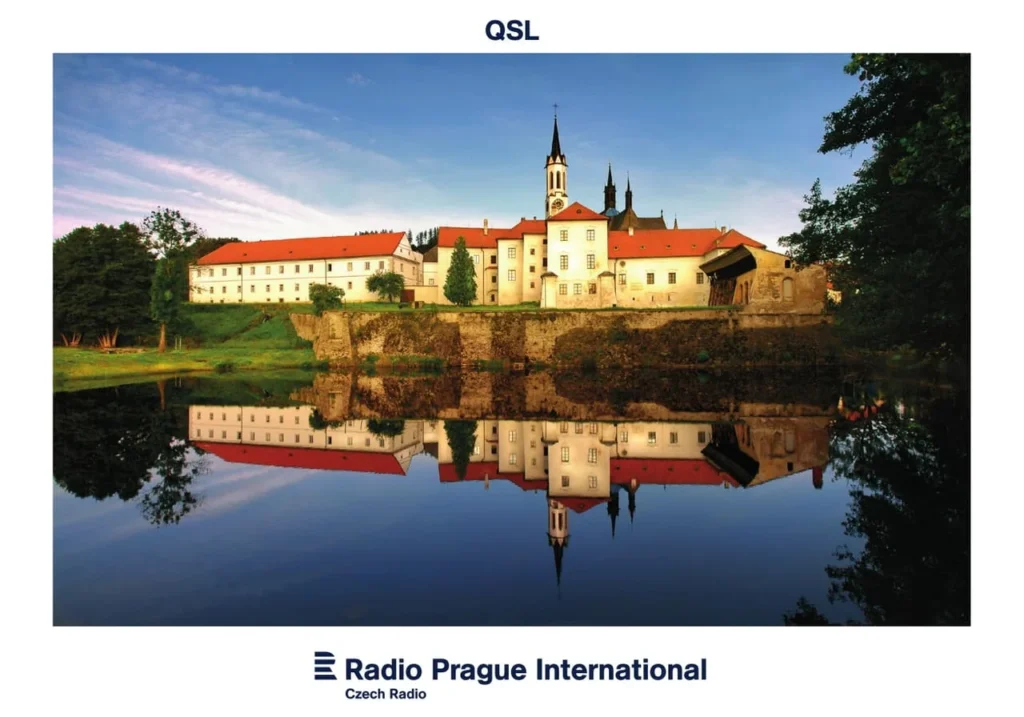 Castelo refletido em lago, representando 90 anos da Radio Prague.