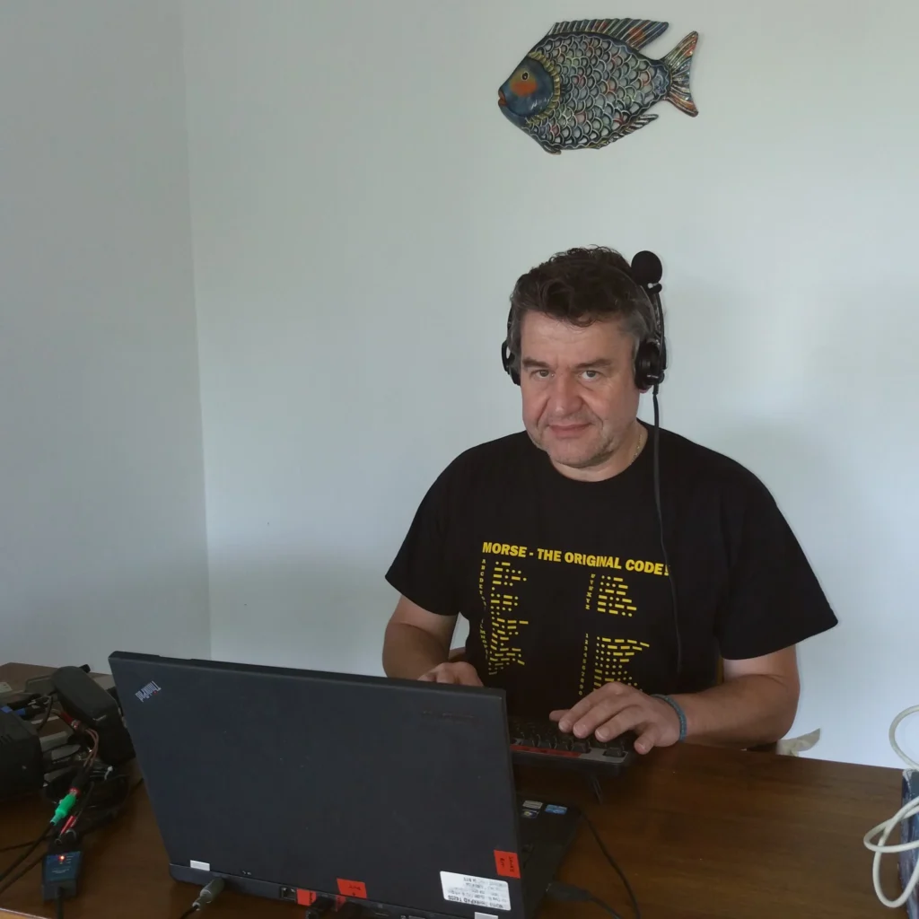 Radioamador F5HRY operando em estação com laptop e equipamentos de comunicação