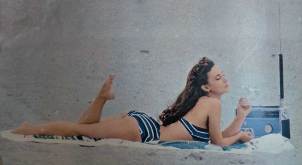 Mulher de biquíni com rádio Zenith na praia em 1958.
