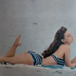 Mulher de biquíni com rádio Zenith na praia em 1958.